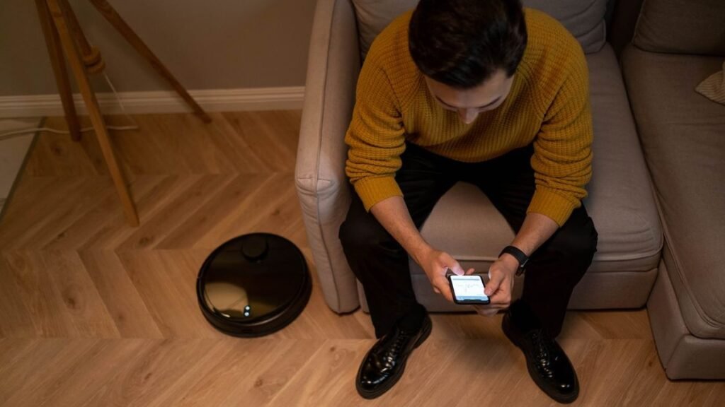 Persona controlando su hogar inteligente desde el movil en el salon