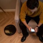 Persona controlando su hogar inteligente desde el movil en el salon