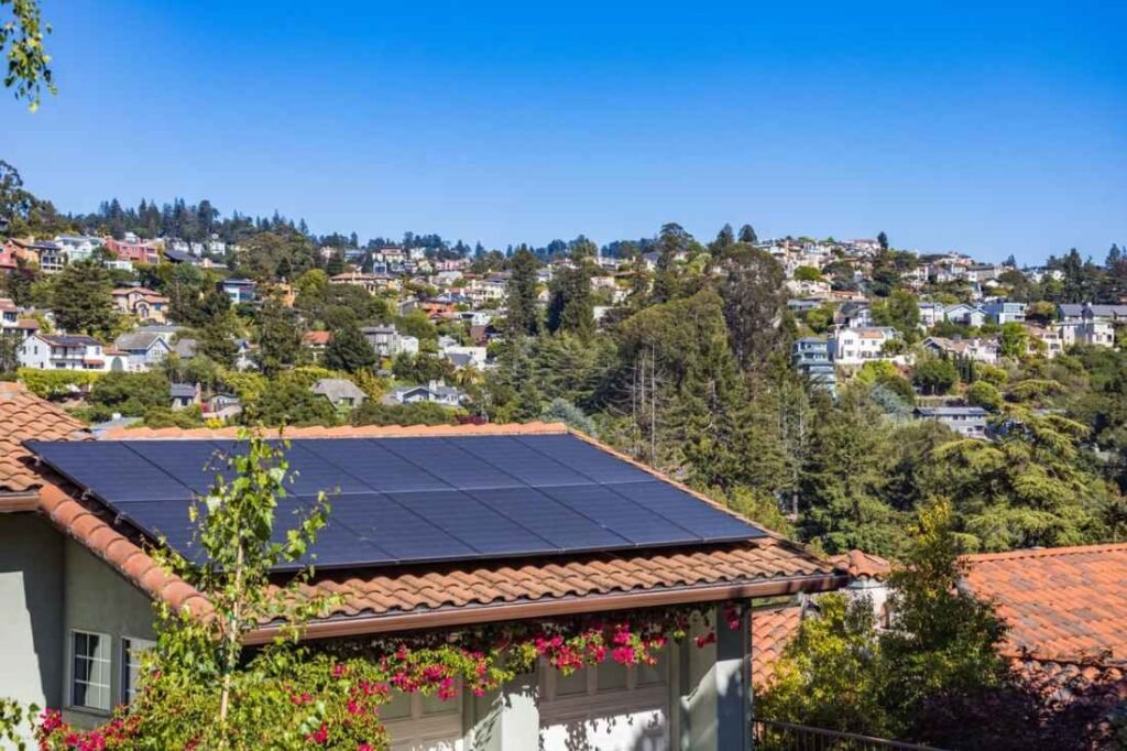 Domótica solar: casa con placas solares en el tejado conectadas a un hogar inteligente