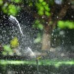 Programador de riego wifi regando el césped de un jardín